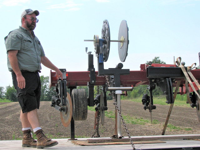 MU Extension agronomist Rusty Lee shows a modified conservation ripper used to bury drip tape for irrigating corn and soybean fields. (DTN/The Progressive Farmer photo by Linda Geist)